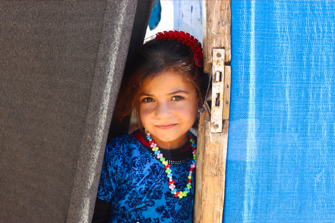 A little girl standing in the doorway of a tent