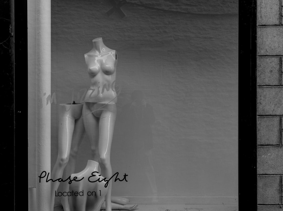 a black and white photo of a mannequin in a window